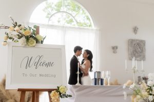 Welcome to wedding sign with bride and groom in background