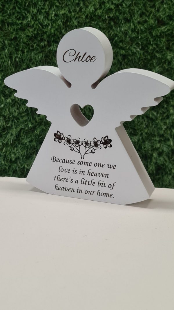 Close-up of engraved flowers and heart on personalised wooden memorial angel